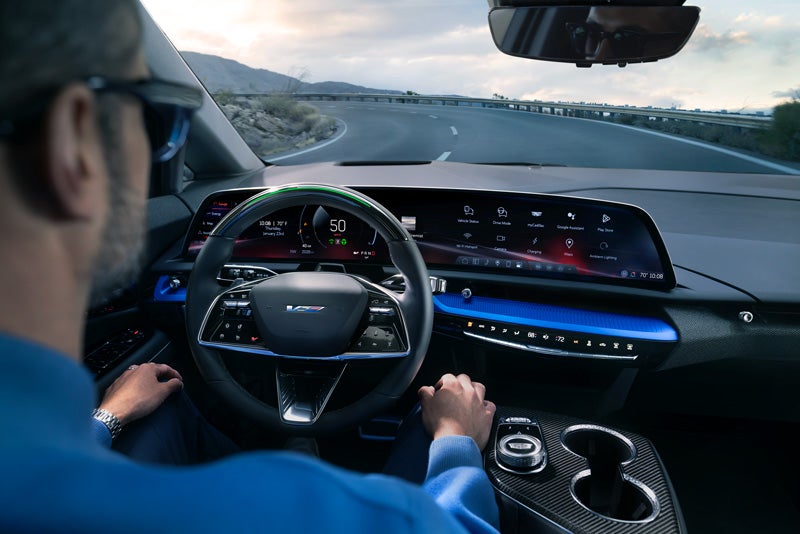 Front View of the 2026 OPTIQ-V Driving Through the Dusk Utilizing its Headlights | Camargo Cadillac in CINCINNATI OH