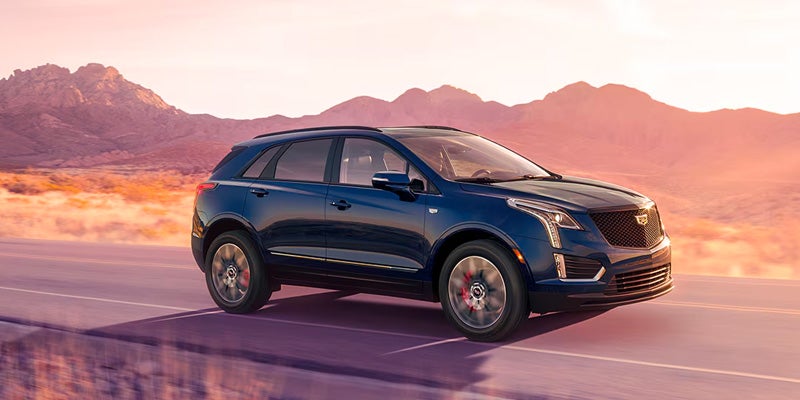 Side profile of the 2025 Cadillac XT5 driving through Cincinnati streets