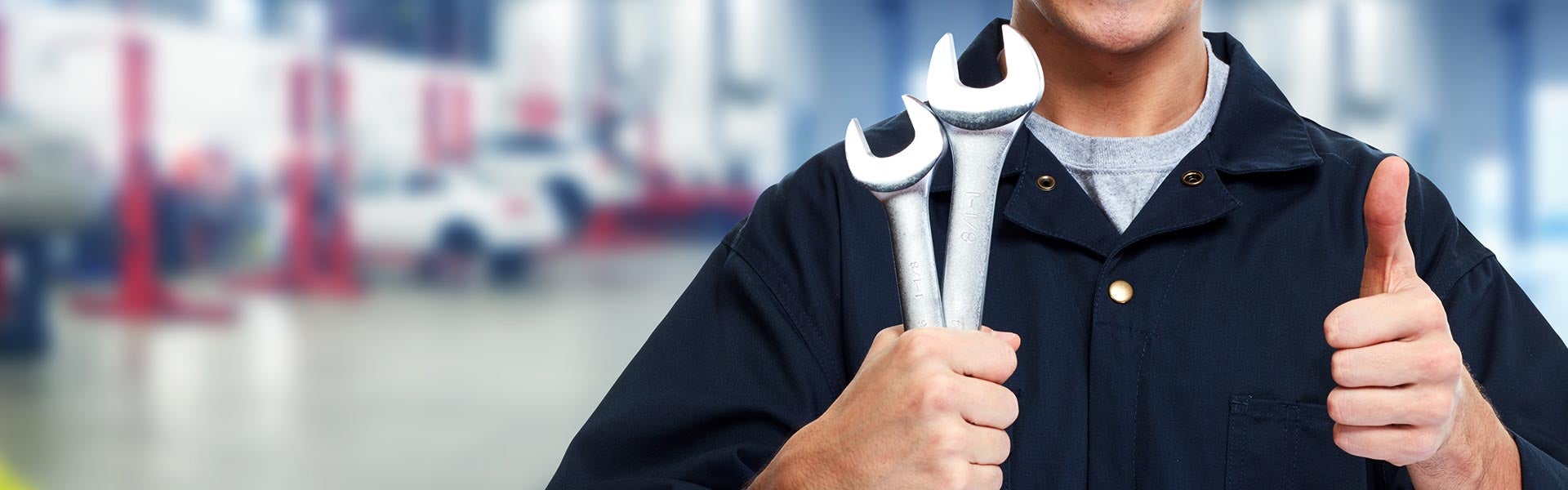Photo of a person holding wrenches and giving a thumbs up
